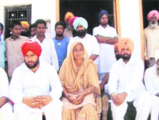 Kulwinder Kaur, mother of Dharampal Singh, in her house along with residents of Jhoke Thealsinghwala village in Ferozepur.