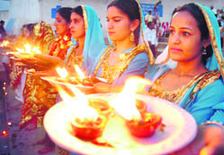 Women pray on the concluding day of the Baisakhi festival at Har Ki Poudi temple in Jammu. 