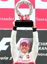 Jenson Button holds his trophy aloft at the Shanghai International Circuit in 