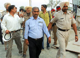 Cops take away two persons accused of assaulting the Tribune lensman from the premises of the Civil Hospital in Bathinda 