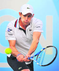 Andy Roddick returns the ball during his match against Igor Kunitsyn at the Queen's Club Championships in west London on Tuesday
