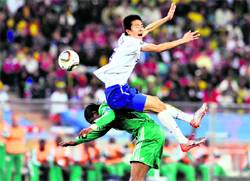 South Korea�s Kim Jung-Woo flies over the top of Nigeria�s Nwankwo Kanu (bottom) during their match in Durban on Tuesday