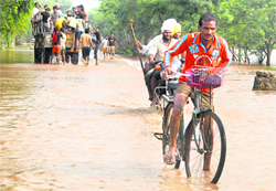 Villagers pass on a flooded road in Patiala distric