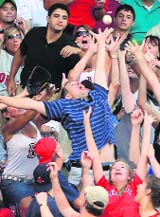 Fans reach for a foul ball off the bat of the Detroit Tigers� Jeff Frazier in the second innings of their MLB American League baseball game against the Boston Red Sox at Fenway Park in Boston, Massachusetts 