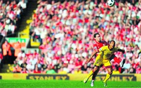 Liverpool�s maxi Rodriguez (L) fights for the ball with Arsenal�s Theo Walcott at Anfield