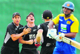 New Zealand cricketer Nathan McCullum (2 L) celebrates with captain Ross Taylor (L) and wicketkeeper Gareth Hopkins (2 R) after dismissing Sri Lankan captain Kumar Sangakkara (R) in Dambulla on Friday. 