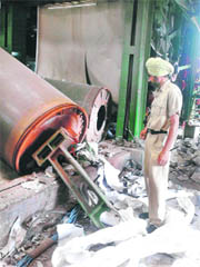 A policeman looks at the damage caused by a blast at a paper mill in Malerkotla on Friday night. 
