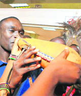 800-mt record holder David Rudisha drinks milk from a traditional guard upon arrival at the Jomo Kenyatta airport in Nairobi on Wednesday.
