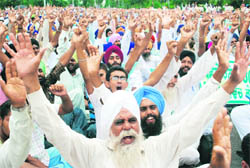 Farmers stage a protest in Mohali on Monday.