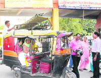 A discharged patient (seated in the autorickshaw) leaves the Civil Hospital, Jalandhar, with her folding bed which she had brought along on Monday.