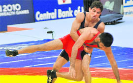 Rajender Kumar (back) competes against Pakistan�s HUssian Azhar i the 55 kg men�s Greco-Roman wrestling final. Kumar won the gold.