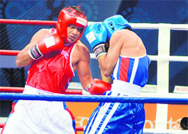 Akhil Kumar (red) of India competes against Qadir Khan (blue) of Pakistan in the preliminaries category at the Talkatora Indoor Stadium in New Delhi on Thursday. 