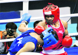 Suranjoy (red) in action against Pakistan's Haroon Iqbal in the 52-kg category boxing event of the Commonwealth Games in New Delhi on Monday.