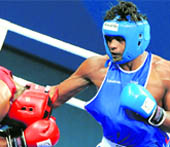 Paramjeet Samota throws a punch towards Tariq Abdul Haqq of Trinidad and Tobago during their super heavyweight +91kg boxing bout for the gold medal