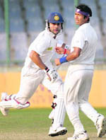 Bengal�s Ashok Dinda (R) watches as Virat Kohli takes a run in New Delhi on Tuesday
