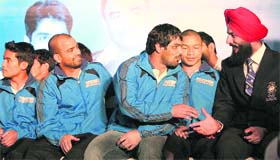 Wrestler Sushil Kumar (C) speaks to Indian hockey captain Rajpal Singh (R) as boxer Akhil Kumar looks on