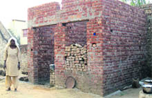 Jagir Kaur stands near an incomplete room constructed by the panchayat in Bhinder Kalan village in Moga district