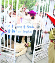 Members of the Unemployed Linemen Union hold a protest in support of their demands in front of the headquarters of the Punjab State Power Corporation in Patiala on Tuesday.
