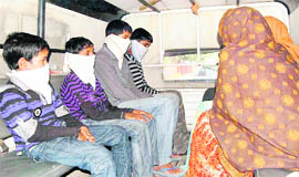 The arrested members of an inter-state gang of robbers, including two children and two women, being taken away in a police vehicle in Patiala on Tuesday.