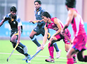 Hiroki Sakamoto of Japan (C) controls the ball through Indian players during their group B game at the Aoti hockey field in Guangzhou on Sunday.
