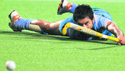 Gurbaj Singh watches the ball as he slips on the ground against Malaysia during their semifinal in Guangzhou on Tuesday. Malaysia defeated India in extra time by 4-3 and qualified for the final. 