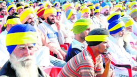 Supporters of Manpreet Badal wear coloured bands around their turbans in Golewal village in Faridkot district on Saturday.