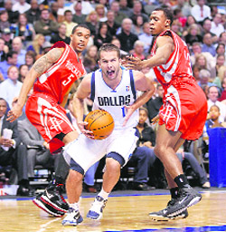 Dallas Mavericks point guard Jose Juan Barea (C) drives between Houston Rockets shooting guard Courtney Lee (L) and Ishmael Smith during the first half of their NBA basketball game in Dallas 