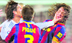 Real Madrid's Sergio Ramos (left) clashes with Barcelona's Carles Pujol (right) during a Spanish La Liga soccer match in Barcelona 