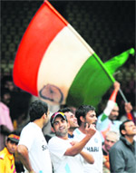 Gautam Gambhir (2ndL) talks to teammates as a fan waves the Tricolour in the background during a training session ahead of the fourth ODI against New Zealand in Bangalore