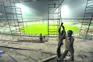 Construction workers pull a rope as they finish roof construction of a stand at the Eden Gardens Stadium in Kolkata on Thursday. India suffered a sporting humiliation when its most famous ground was declared unfit to host its first fixture for next month's cricket World Cup.