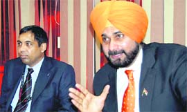 Navjot Singh Sidhu addresses a press conference in Amritsar on Tuesday. Next to him is Airport Director Sunil Dutt.