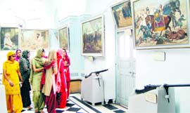Visitors take a look at a painting at the Central Sikh Musuem in Amritsar on Sunday.