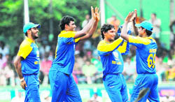 Sri Lankan players celebrate the fall of a West Indian wicket in Colombo on Sunday 