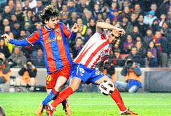 Barcelona's Lionel Messi (L) scores against Atletico Madrid during the Spanish First Division match at Nou Camp stadium in Barcelona on Sunday.