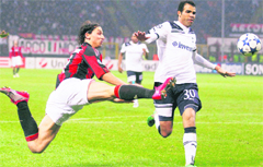 AC Milan forward Zlatan Ibrahimovic (left), challenges for the ball with Tottenham Hotspur�s Sandro during their Champions League match in Milan