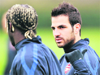 Arsenal's Cesc Fabregas (R) talks to Bacary Sagna (L) during a team training session at the club's Colney training ground in Londo