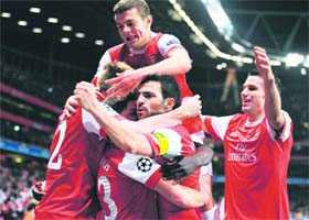 Arsenal's players celebrate after scoring a goal during their Champions League match against FC Barcelona in London