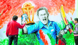 Artist Amit (left) expresses his enthusiasm for the World Cup through a painting in Jalandhar on Friday. His daughter and an assistant help him in his work.
