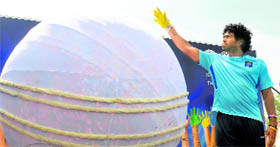 Lasith Malinga imprints his palm on a giant cricket ball at Suriyawewa on Friday.