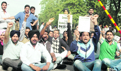 Members of the NSUI hold a protest in front of the main gate of Punjabi University in Patiala on Friday.