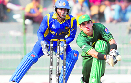 Pakistan�s Misbah-ul-Haq (R) hits a shot as Sri Lanka�s Kumar Sangakkara looks on in Colombo on Saturday.