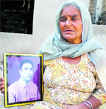Chhinder Kaur with the photograph of her son Sukhmander Singh in Bhucho Kalan, Bathinda, on Sunday