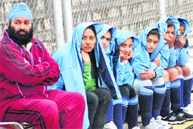 Tarn Taran girls cover themselves from the rain at the Olympian Surjit Singh Hockey Stadium in Jalandhar