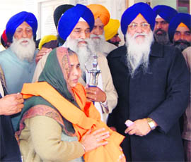 SGPC chief Avatar Singh Makkar (right) and Akal Takht Jathedar Gurbachan Singh present a siropa to a survivor of the Rewari massacre in the Golden Temple complex in Amritsar on Friday.