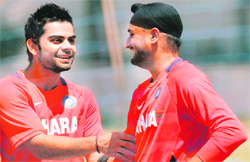 Virat Kohli (L) and Harbhajan Singh laugh during a practice session on the eve of their match against Ireland in Bangalore on Saturday.