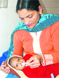 A nurse at a hospital in Amritsar feeds a girl child who was abandoned in a �panghura�put up by the district administration.