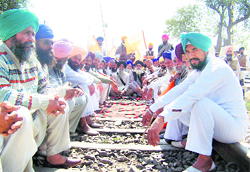 Activists of the Jat Reservation Struggle Committee sit on a railway line near Ferozepur