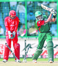 Kenya's Collins Obuya is bowled by Canada's Harvir Baidwan as wicketkeeper Ashish Bagai watches in the match in New Delhi on Monday. 