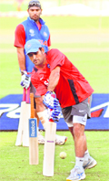 Yuvraj Singh (behind) watches MS Dhoni bat during a training session at the Feroze Shah Kotla Stadium in New Delhi