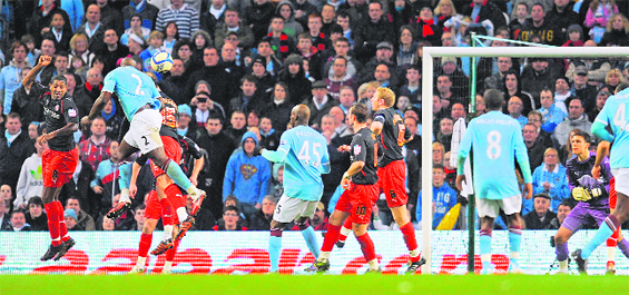 Manchester City's English defender Micah Richards (2nd L) heads the opening goal of the FA Cup quarter-final match against Reading at The City of Manchester Stadium on Sunday. City won 1-0.